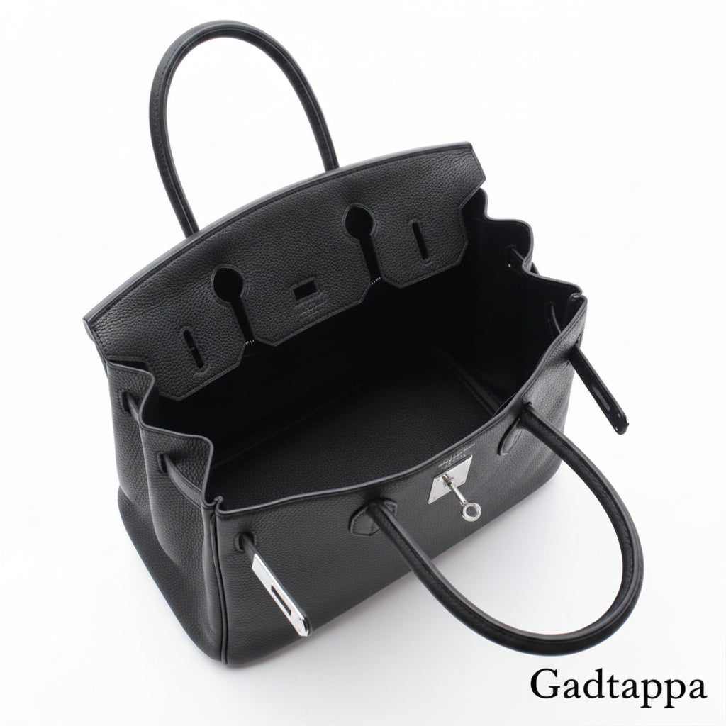 Close-up of a black leather bag with visible stitching on a white background