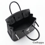 Close-up of a black leather bag with visible stitching on a white background